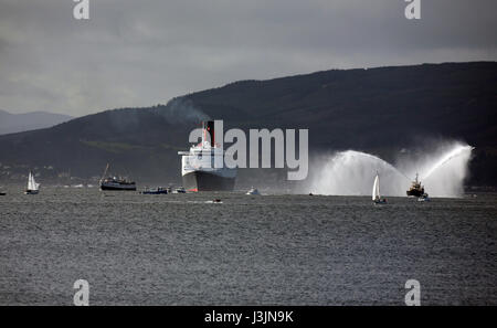 Cunard liner QE2 segeln, bis der Fluss Clyde, Schlepper Feuer Boot mit einer Flotte von Booten auf ihre letzte Reise vorbei an der Cloch Leuchtturm Schottland Großbritannien Stockfoto