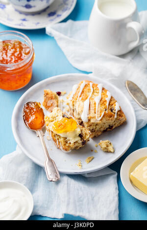 Scones mit Marmelade und Butter auf Platte. Blauer Hintergrund. Stockfoto