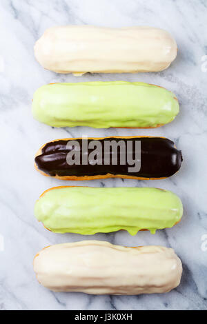 Eclair, traditionelle französische Dessert Marmor Hintergrund. Ansicht von oben Stockfoto