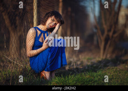 Schönes Mädchen im Abendkleid wurde geworfen und leidet. Stockfoto