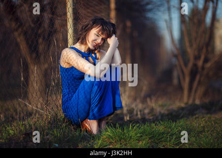 Schönes Mädchen im Abendkleid wurde geworfen und leidet. Stockfoto