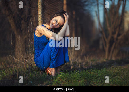 Schönes Mädchen im Abendkleid wurde geworfen und leidet. Stockfoto