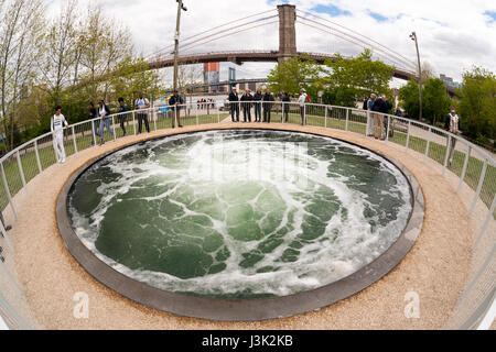 Besucher auf der Brooklyn Bridge Park in New York am Mittwoch, 3. Mai 2017 sind durch Installation des Künstlers Anish "Abstieg" begeistert. Das Kunstwerk besteht aus einen kontinuierlich wirbelnden Strudel des Wassers in einem 26 Fuß breiten Pool hypnotisch kommandierte die Aufmerksamkeit des Betrachters, wie es in die Tiefe gesaugt erinnert. Die Installation wird von der Kunst im öffentlichen Raum-Fonds finanziert die ihr 40-jähriges Bestehen feiert. "Abstieg" wird bis 10. September 2017 am Pier 1 in den Park zu sehen. (© Richard B. Levine) Stockfoto