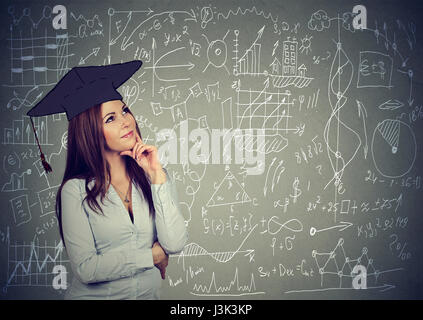 Junge Frau in Graduation Cap Bildung nachzudenken, Work Life-balance Planung zukünftiger stehend von Info-Grafiken-Tafel-Hintergrund Stockfoto