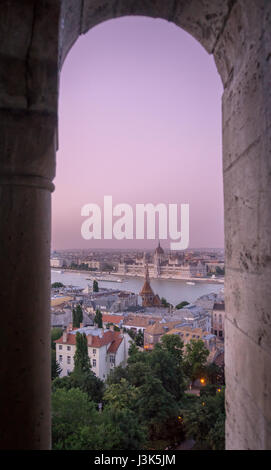 Durch ein Schloss Fenster, die Aussicht von Buda in den Vordergrund mit dem ungarischen Parlament auf der Pester Seite von Budapest. Stockfoto