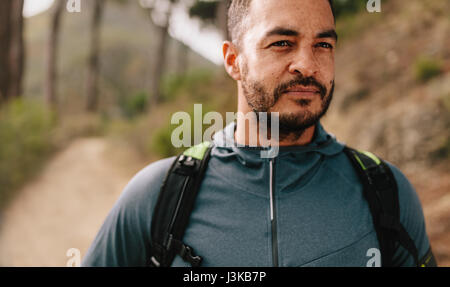 Porträt von Fit junge Mann im Freien auf Bergweg. Gesunde junge männliche Läufer auf Wald Trail wegsehen. Stockfoto