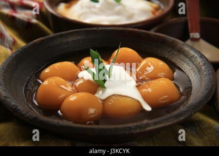 Traditionelle javanische Dessert Brei aus Klebreis und Süßkartoffel-Kugeln auf Steingut Geschirr Stockfoto