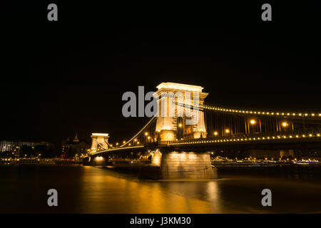 Golden leuchten Budapests historische Kettenbrücke, die Donau, Ansicht von Buda, Pest erstreckt. Stockfoto