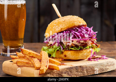 Sandwith zog Schweinefleisch mit Pommes Frites auf hölzernen Hintergrund Stockfoto