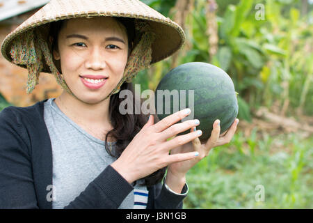 Bäuerin halten frische Wassermelone im Feld Stockfoto