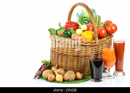 Gesunde Ernährung Konzept - Korb voller vielfältige Gemüse und verschiedenen Gemüsesäfte in Gläser auf weißem Hintergrund Stockfoto