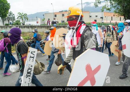 Anhänger der Opposition mit hölzernen Schilden und Steinen in ihren Händen während einer Demonstration gegen den venezolanischen Präsidenten Nicolás Maduro in Caracas, Ven Stockfoto