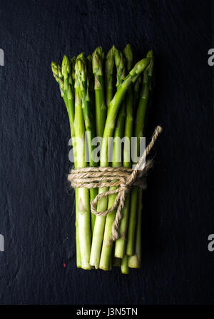 Grüne frische Spargel auf schwarzem Schiefer Stein Hintergrund Stockfoto