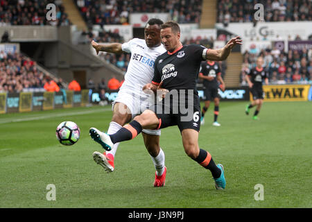 Swansea City Jordan Ayew (links) und Everton Phil Jagielka Kampf um den Ball in der Premier League match bei der Liberty Stadium, Swansea. Stockfoto