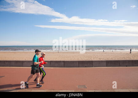 Edinburgh, Schottland. 6. Mai 2017. Zwei Mann läuft an der Strandpromenade von Portobello in Edinburgh, die Hauptstadt von Schottland, Großbritannien. Wetter: 6. Mai 2017 Temperaturen oberhalb Saisondurchschnitte abseits der Küsten, vor allem in West Lothian Höchststand. Aber es wird trüber als Freitag, besonders über den Süden durch und später über die Ostküste, wo einige niedrige Wolkendecke entwickelt. Bildnachweis: Gabriela Antosova/Alamy Live-Nachrichten Stockfoto