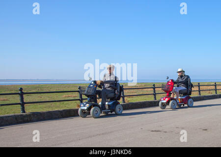 Rollstuhlfahrer bei Lytham St Annes on Sea, Lancashire. UK Wetter. 7. Mai, 2017. Senioren, Rentner, Behinderte mit Mobility Scooter auf hellen, sonnigen Start in den Tag als gebietsansässige Person asnd Urlauber genießen Sie das Meer und die Promenade in diesem Lancashire Stadt mit Blick auf die Irische See. und Ribble Estuary. Kredit; MediaWorldImages/AlamyLiveNews Stockfoto