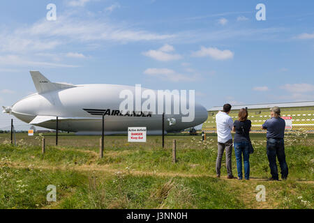 Cardington, Bedfordshire, UK. 7. Mai 2017. Die Hybrid-Luft Fahrzeuge Airlander 10 auf den neuen Mobile Mooring Mast in Cardington Flugplatz. Zuschauer die Aussicht genießen, während unerwünschte Eindringlinge als das Flugzeug Sicherheits-Sensoren auf Beiträge innerhalb des Zauns fernzuhalten, HAV 304 ist fast fertig, es ist 2017 Flugerprobungsprogramm beginnen. Bildnachweis: Mick Flynn/Alamy Live-Nachrichten Stockfoto