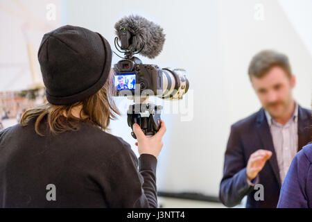 Kameramann schießt ein Interview mit einem Mann Stockfoto