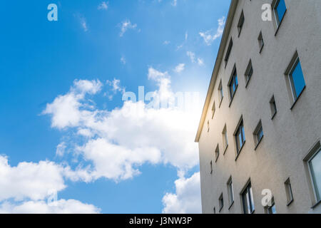 Himmel mit Wolkengebilde und einfaches Haus mit der Sonne im Rücken Stockfoto