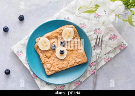 Teddy Bär förmigen Erdnussbutter-Bananen-Toast für Kinder. Lustige Tier Gesicht Toast für Kinder Frühstück oder Mittagessen. Ansicht von oben Stockfoto