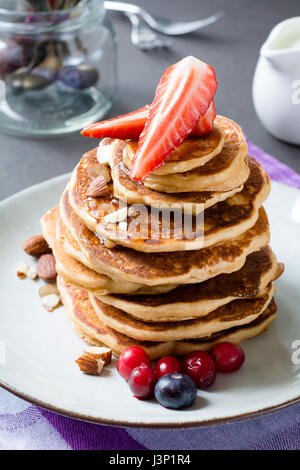 Stapel von Pfannkuchen mit frischen Früchten und Honig. Nahaufnahme, vertikale Essen Foto Stockfoto