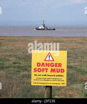 4. Mai 2017 - Gefahr weichen Schlamm Warnschild auf der Uferlinie in Portishead mit einem Schlepper vorbei Stockfoto