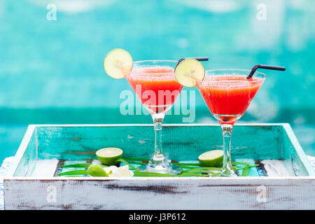 Erdbeer Margarita cocktail auf bunten hölzernen Hintergrund mit Palmzweig. Stockfoto