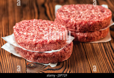 rohen Boden Rindfleisch Fleisch Frikadellen auf Papier, Holz Hintergrund Stockfoto