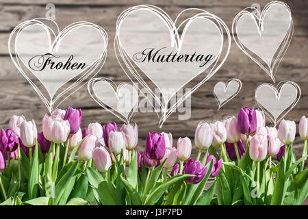 glückliche Mutter Tag deutsche Text Herz mit rosa und weißen Tulpen auf rustikalen hölzernen Hintergrund Grußkarte Frühlingsblumen Stockfoto