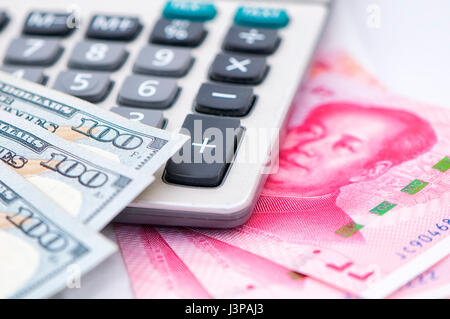 100 US-Dollar und 100 Renminbi Rechnungen auf einen Rechner. Stockfoto