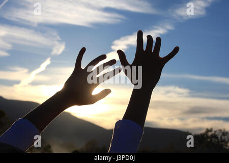 Mädchen die Hände nach dem Himmel greifen Stockfoto