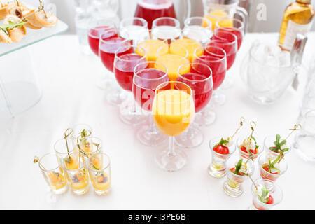 Restaurant-Stehtische in der Cocktail-Party. Eis in einer durchsichtigen Glasschüssel und Metall kleben. festliches Buffet, alkoholische und Alkohol freie Getränke. Stockfoto