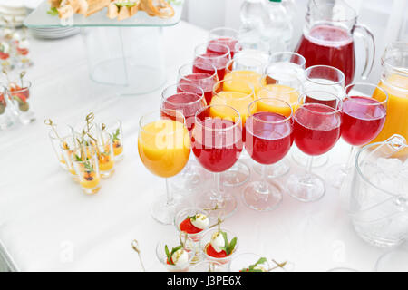 Restaurant-Stehtische in der Cocktail-Party. Eis in einer durchsichtigen Glasschüssel und Metall kleben. festliches Buffet, alkoholische und Alkohol freie Getränke. Stockfoto