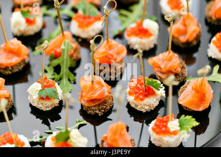 Das Buffet an der Rezeption. Sortiment von kanapees. Bankettservice. catering Essen, Snacks mit Lachs und Kaviar. Roggen, Weizen Brot. selektive Fokus Stockfoto