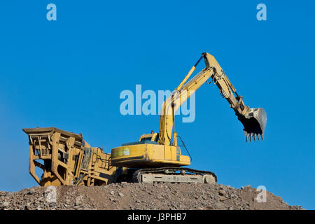 Erdbewegung, die Böden in den wartenden Container laden Stockfoto