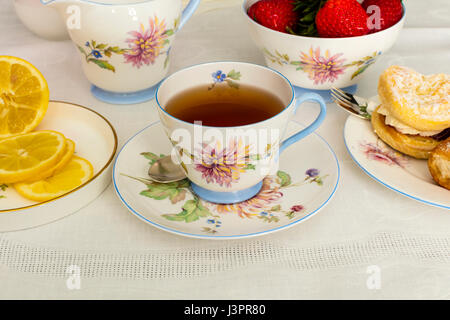 Tasse Tee in einem Vintage Porzellan Teetasse mit frischer Sahne Kuchen serviert. Stockfoto