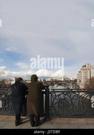 Zwei alte russische Frauen suchen die Skyline von Moskau mit Blick auf die befestigte Anlage des Kreml von der Patriarch-Brücke auf dem Fluss Moskwa Stockfoto