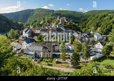 Blick auf eine kleine, idyllische, malerische Dorf Europas befindet sich in einer Kurve eines Flusses in einer grünen, hügeligen Landschaft. Es gibt eine zerstörte Festung auf dem Hügel Stockfoto