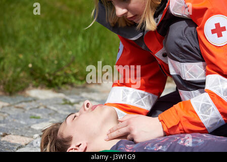 Professionellen Sanitäter bewusstlosen jungen Mann erste Hilfeleistung Stockfoto