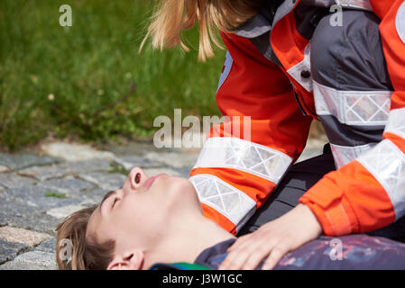 Professionellen Sanitäter bewusstlosen jungen Mann erste Hilfeleistung Stockfoto