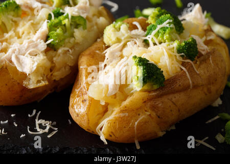 Gesunden Ofenkartoffel mit Käse, Zwiebeln, Brokkoli und Huhn Nahaufnahme auf dem Tisch. horizontale Stockfoto