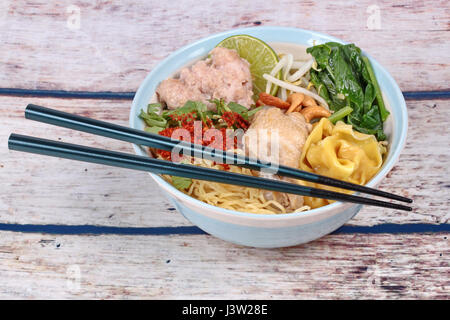 Wie Tom Yum Schweinehackfleisch gekrönt Nudel- und Wan-Tan in scharf saure Suppe gekocht, Huhn, Schlegel, Chili, Sojasprossen, Cashew-Nuss, chinesischer Senf Grünen und gr Stockfoto