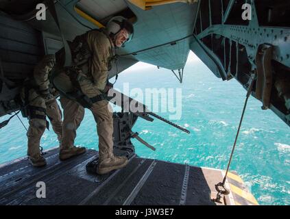 170420-N-TB410-1218 arabischen Golf (20. April 2017) Marine Aircrewman 3. Klasse Max Miller, zugewiesen, die Blackhawks der Hubschrauber Mine Gegenmaßnahmen Squadron (HM) 15 Abteilung 2, sucht für ein Ziel während der Besatzung einer GUA-21.50 Kaliber Maschinengewehr auf der Rückseite eine MH-53E Sea Dragon während einer Ausbildung Evolution vor der Küste von Bahrain. HM-15 zugeordnet ist Task Force 52, Förderung der Grube Gegenmaßnahme-Aktivitäten in den USA 5. Flotte Einsatzgebiet. (Foto: U.S. Navy Mass Communication Specialist 1. Klasse Joshua Bryce Bruns) Stockfoto