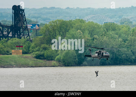 Ein Kentucky Army National Guard UH-60 Blackhawk hisst Flieger aus der Kentucky Air Guard 123. spezielle Taktik-Geschwader in das Flugzeug nach der Durchführung einer simulierten Rettungsmission in den Ohio River in Louisville, Kentucky, 22. April 2017. Die Demonstration war Teil der Donner über Louisville, einer jährlichen Flugschau, die Hunderte von Tausenden von Zuschauern an den Ufern des Ohio zieht. (U.S. Air National Guard Foto von Oberstleutnant Dale Greer) Stockfoto