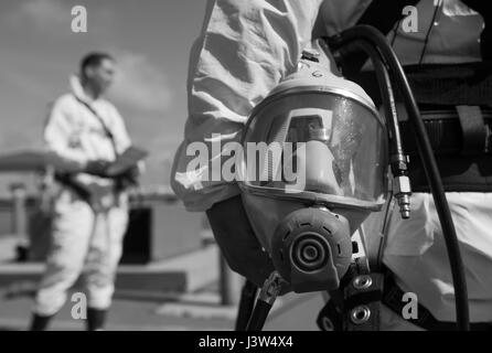 Troy Bodey, 9. Civil Engineer Squadron Wasser und Kraftstoffen Systemwartung, hält sich an seine Gasmaske beim Anhören einer Sicherheits kurz durch die beengten Eintrag Supervisor bei Beale Air Force Base, Kalifornien, 27. April 2017 gegeben. Aufsichtsbehörden auf engstem Raum Eintrag Team sind verantwortlich für die Zuweisung von Rollen und sicherstellen, dass Sicherheitsprotokolle eingehalten werden. (Foto: U.S. Air Force Airman 1st Class Justin Parsons/freigegeben) Stockfoto