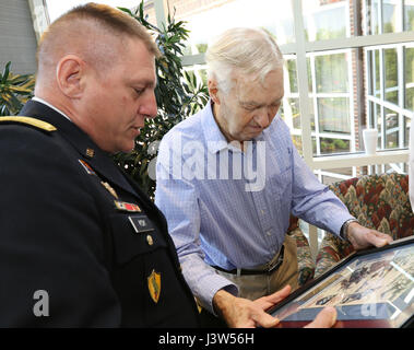 Generalmajor Troy D. Kok, Kommandierender general der US Army Reserve 99. regionale Unterstützung Befehl, präsentiert gerahmte Bilder aus dem zweiten Weltkrieg Claude Hodges, ein 99. US-Infanteriedivision-Veteran, diente während der Ardennenoffensive und lebt derzeit bei der Virginia Veteranen Care Center in Roanoke, Virginia. Kok besucht Hodges und andere Veteranen in der Mitte April 28. Stockfoto