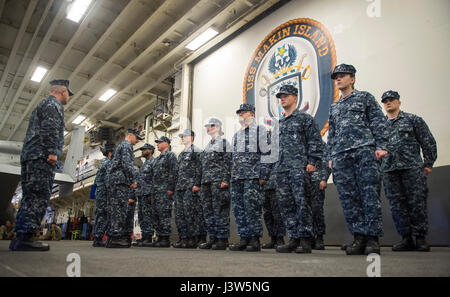 170428-N-LI768-041 Pazifik (28. April 2017) Segler stehen in Bildung als USS Makin Island (LHD 8) Kommandierender Offizier Captain Mark A. Melson eine einheitliche Prüfung in das Schiff Hangarbucht führt. Die Makin Island amphibische bereit Group und 11. Marine Expeditionary Unit sind aus einer siebenmonatigen Bereitstellung an den US-3., 5. und 7. Flotte Einsatzgebiete zurück.  (Foto: U.S. Navy Mass Communication Specialist 3. Klasse Devin M. Langer) Stockfoto