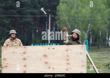 Ukrainische Soldaten mit dem 1. Airmobile Bataillon, 79. Air Assault Brigade, wirft eine Praxis-Granate während Yavoriv GÜZ Trainer beobachtet und Feedback während des Trainings auf die Yavoriv CTC International Peacekeeping und Security Center in der Nähe von Yavoriv, Ukraine, am 29. April liefert.  Yavoriv CTC-Personal, zusammen mit Mentoren aus der US-Armee 45. Infantry Brigade Combat Team, führen Granate Einarbeitung und Beschäftigung Ausbildung an die Soldaten aus der 1-79. während der Rotation des Bataillons durch Yavoriv CTC. 45. ist in die Ukraine als Teil des Gelenks eingesetzt. Stockfoto