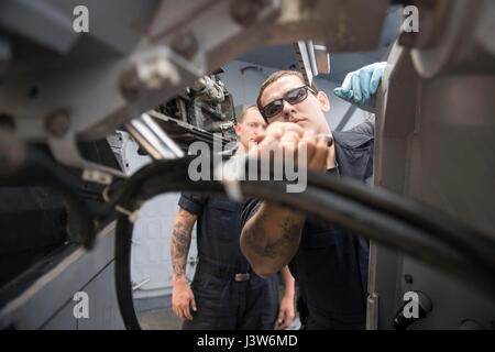 170430-N-FQ994-046 Mittelmeer (30. April 2017) Gunner's Mate Seaman David Melgarlae aus New Orleans, führt Wartungsarbeiten an Mark 38 25 mm Chain gun Komponenten an Bord der Arleigh-Burke-Klasse geführte Flugkörper Zerstörer USS Ross (DDG 71) 30. April 2017. Ross, vorwärts-eingesetzt in Rota, Spanien, führt Marinebetriebe in den USA 6. Flotte Bereich der Maßnahmen zur Erhöhung der Sicherheit der Vereinigten Staaten in Europa und Afrika interessiert. (Foto: U.S. Navy Mass Communication Specialist 3. Klasse Robert S. Price/freigegeben) Stockfoto