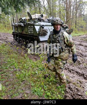 Ein Soldat der Queen Royal Hussars Realmpools, 20. gepanzerten Infanterie-Brigade, folgt eine britische Bulldogge Schützenpanzer durch den tiefen Schlamm durch Dauerregen während Saber Junction 17 an der Joint Multinational Readiness Center in Hohenfels, Deutschland, Mai 2 verursacht. Säbel Junction 17 ist der US-Army Europe 2. Kavallerie-Regiment Kampftraining Zentrum Zertifizierung Übung, statt an den Joint Multinational Readiness Center in Hohenfels, Deutschland, April 25-Mai 19, 2017. Die Übung soll die Bereitschaft des Regiments, einheitliches Land Betrieb durchzuführen Stockfoto